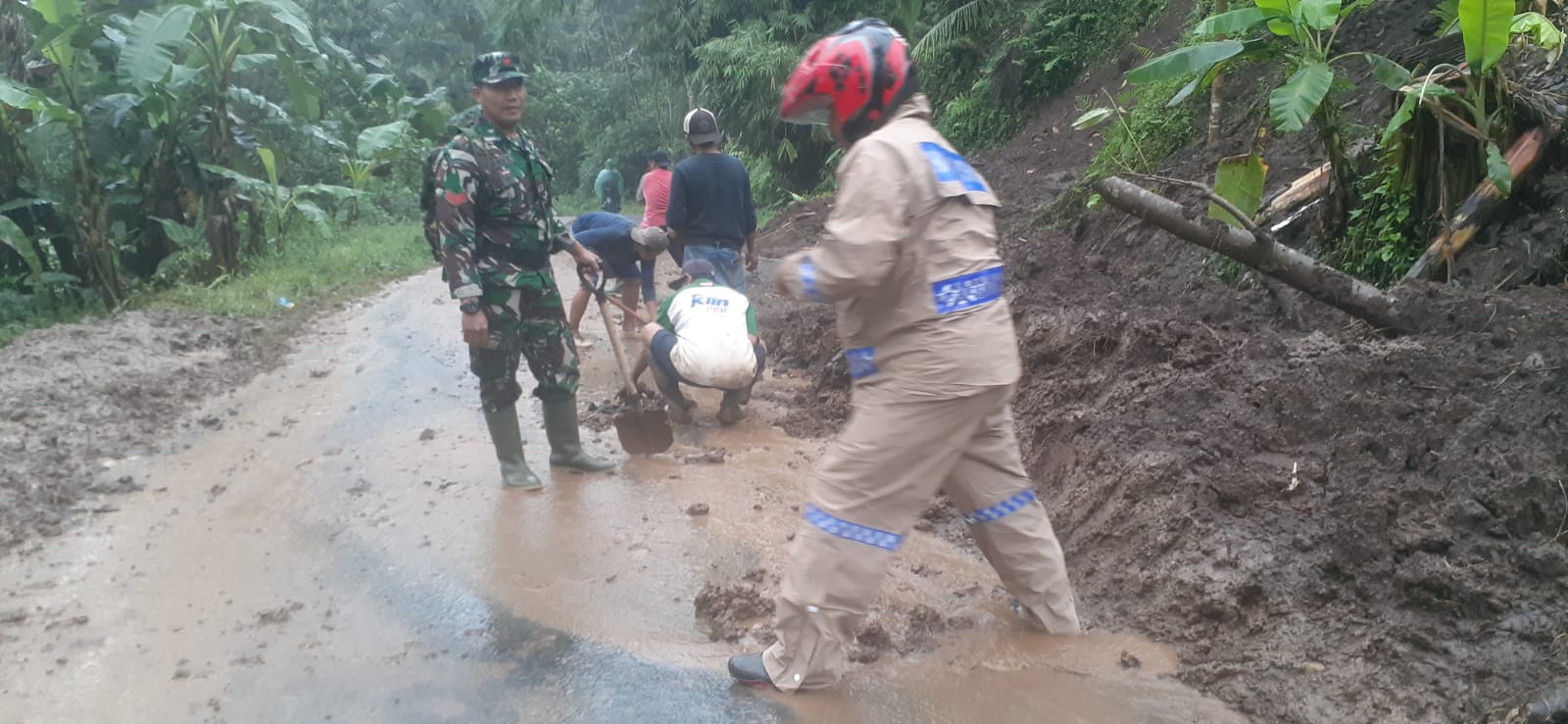 Gotong – royong Polisi dan TNI Bersama Warga Bersihkan Tebing Longsor di Banyuwangi