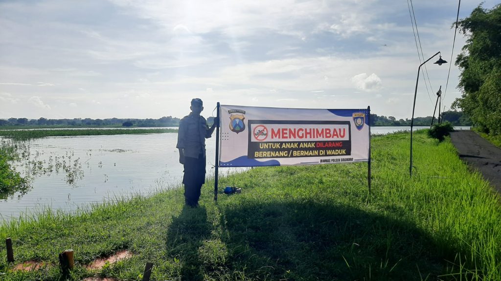 Personil Polsek Solokuro Pasang Banner Himbauan Larangan Bermain dan Berenang di Waduk Njajong