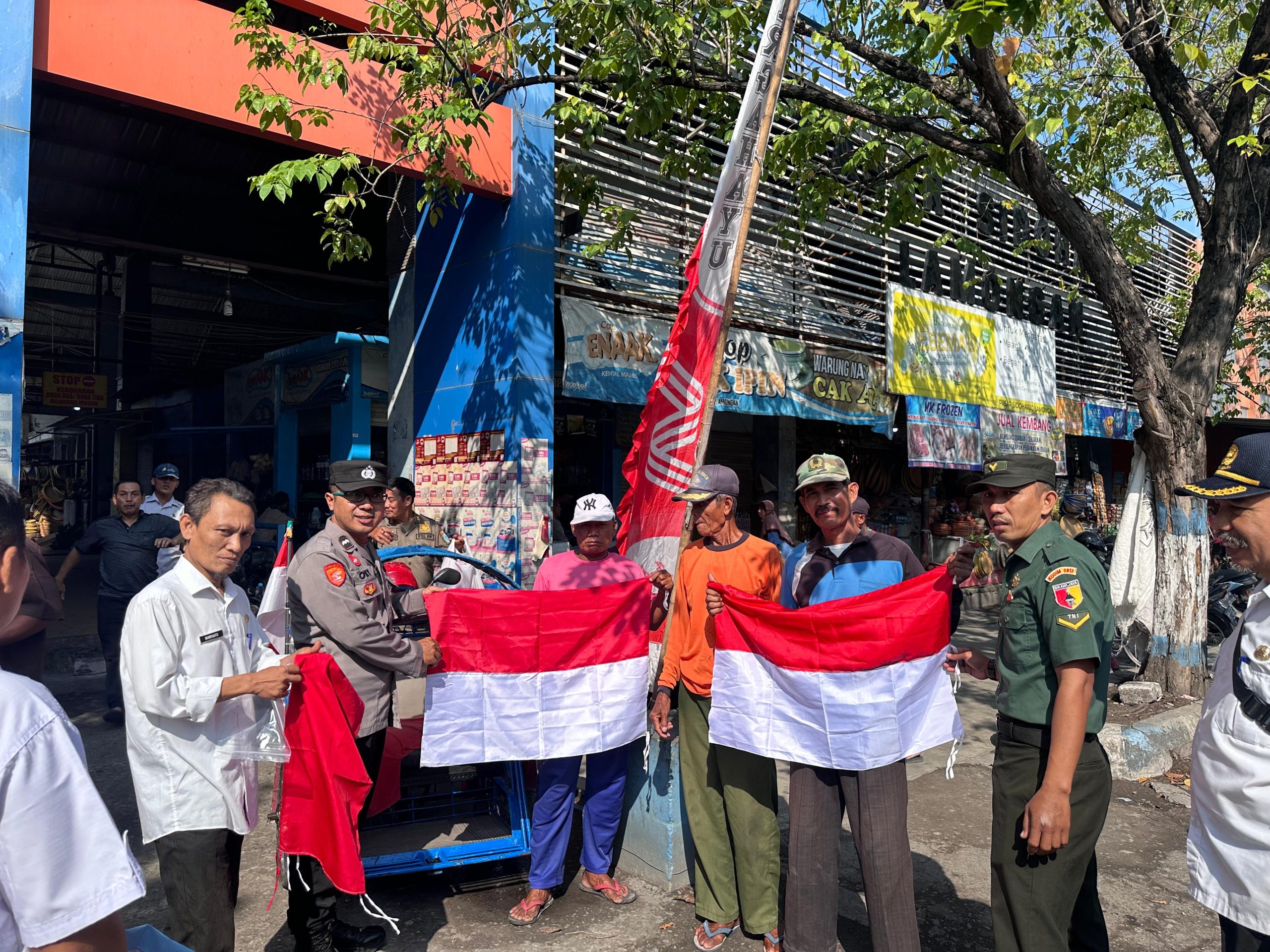 Polsek Lamongan Kota dan Forkopimcam Bagikan Bendera Merah Putih di Pasar Sidoharjo Sambut HUT RI ke-80